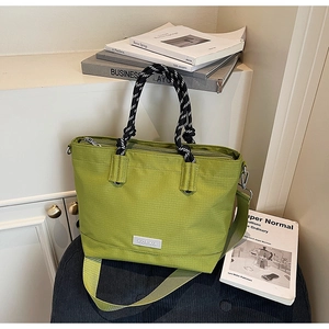 Détail du sac cabas vert avec poignées en corde tressée et large bandoulière en nylon