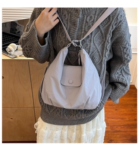 Lavender purple nylon crossbody bag styled with a grey sweater in a home office setting