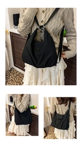 Detail of minimalist black nylon tote bag with wide adjustable strap and pleated texture