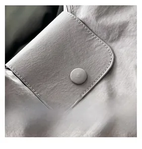 Detailed view of grey nylon fabric with flap pocket, stitching and matching buckle