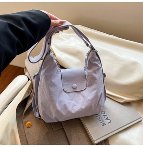 Detailansicht der lavendelfarbenen Nylon-Umhängetasche mit verstellbarem Gurt und Klappe