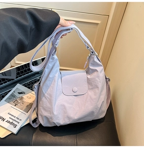 Detailansicht einer fliederfarbenen Hobo-Tasche aus Nylon mit breitem Schulterriemen