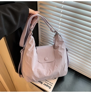 Detail of light purple nylon crossbody bag with adjustable wide strap and flap closure