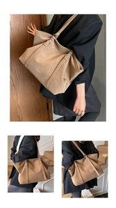 Detail view of khaki tote bag featuring matte texture and adjustable buckle straps