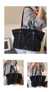 Detail of black suede tote bag featuring silver eyelets and adjustable shoulder strap