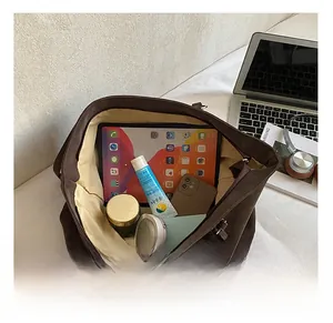 Spacious interior of large brown tote bag showing capacity for tablets and cosmetics