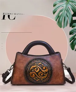 Macro detail of brown leather bag featuring traditional embossed patterns and round handle