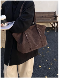 Vue de rue d'un grand sac cabas en daim marron foncé avec boucles métalliques et détails