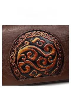 Detailed close-up of retro brown leather handbag with embossed vintage pattern