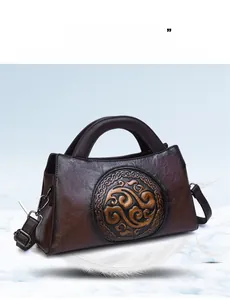 Close-up of vintage brown leather handbag featuring embossed circular traditional motif