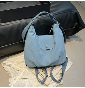 Detail der hellblauen Nylon-Umhängetasche mit Faltenstruktur und verstellbarem Gurt