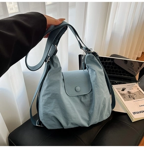 Detail der blauen Nylon-Umhängetasche mit Klappverschluss und Web-Schultergurt