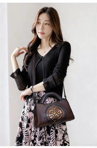 Close-up of vintage embossed leather bag with exquisite floral pattern and round handle