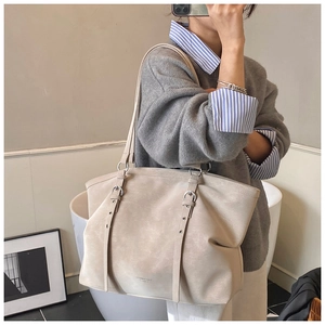 Macro shot of minimalist tote bag with matte texture, dual straps, and silver buckle detail