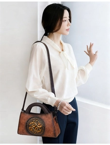Caramel brown embossed leather bag detail shown on model in bright indoor setting