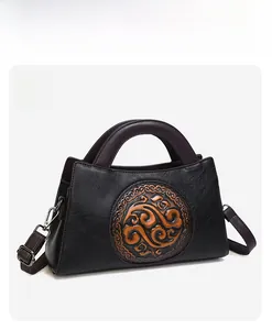 Close-up of vintage black leather bag featuring traditional embossed cloud pattern details