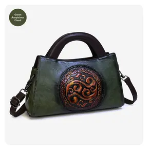 Close-up of retro green leather handbag with embossed round cloud pattern and brown handles