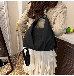 Rückansicht eines Models mit dem vielseitigen schwarzen Nylon-Rucksack mit modischer Klappe