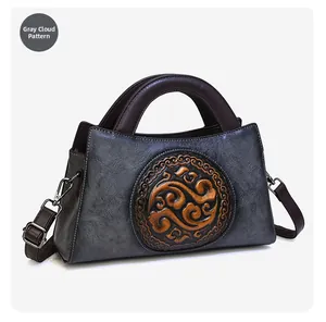 Close-up of retro grey leather handbag featuring embossed orange auspicious cloud pattern