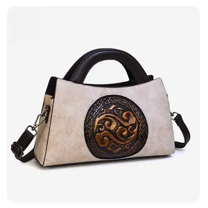 Detail of vintage embossed pattern and textured beige leather strap buckle on shoulder bag