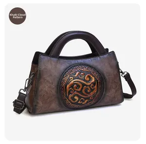 Detailed view of khaki leather handbag with auspicious cloud embossing and bronze hardware