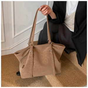 Détail du sac cabas kaki foncé avec texture en cuir vintage et boucles argentées
