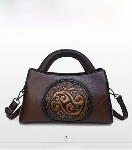 Close-up of retro brown leather handbag with traditional embossed cloud pattern