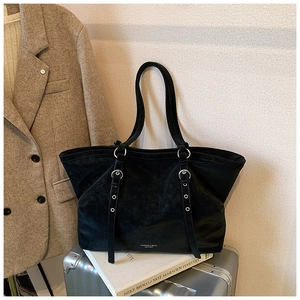Détail du grand sac cabas noir en daim avec anneau argenté et lettrage sur le cuir