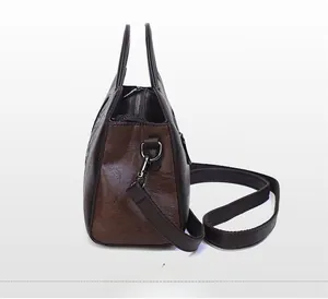 Side view of dark brown faux leather handbag with lychee texture and metallic hardware