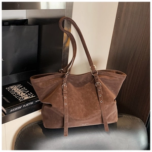 Détail du grand sac cabas en daim marron foncé avec boucles métalliques et lanières