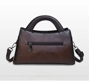 Detail view of the back of a vintage brown gradient leather bag with a zipper pocket