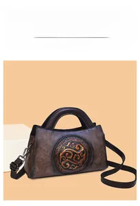 Detailed macro view of dark brown leather handbag with embossed auspicious cloud pattern