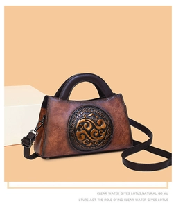 Detail of vintage embossed floral medallion on two-tone brown leather handbag