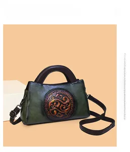 Detailed macro view of retro embossed green leather bag with traditional floral pattern