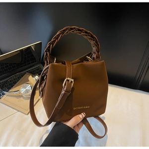 Brown PU leather bucket bag with a unique woven handle and adjustable long shoulder strap