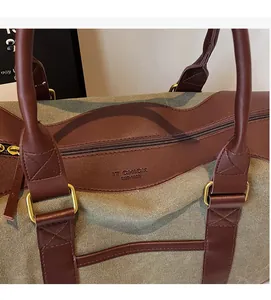 Detail of contrast canvas tote with brown leather handles and embossed logo texture