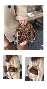 Détail du sac léopard avec poignée en bois, cadre en métal doré et gland marron