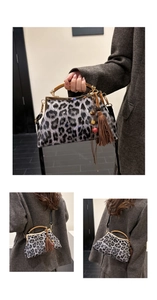 Détail du sac à main léopard avec poignée en bois et accessoire à franges brunes