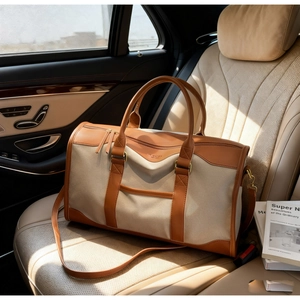 Detail of canvas duffle bag with leather trim on a luxury car seat in bright sunlight
