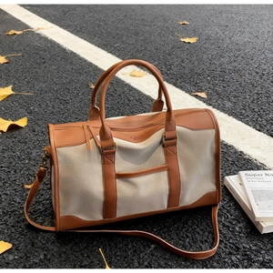 Macro view of the large canvas tote bag showing the leather handle and reinforced stitching