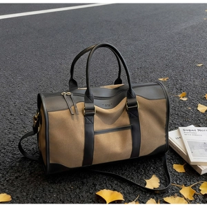 Close-up of contrast canvas tote with leather straps and IT CHICK logo on autumn road