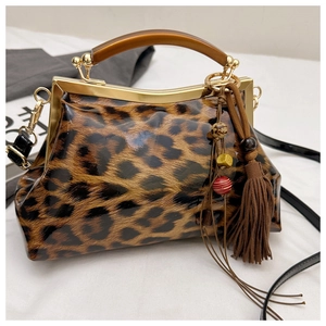 Détail du sac léopard verni avec poignée en résine et pompon à franges marron