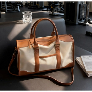 Detail of canvas and leather contrast tote with reinforced handles and removable strap