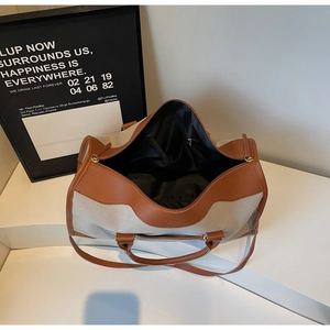 Detail of spacious canvas tote interior with zipper pocket and brown leather trim