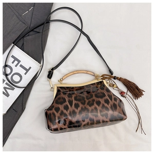 Détail du sac léopard en cuir verni avec cadre métallique et poignée en ambre