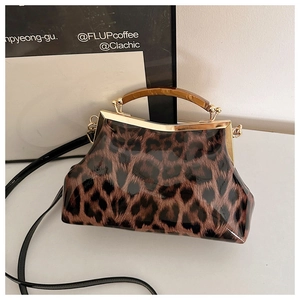 Détail du sac léopard avec poignée en résine ambrée et cadre métallique doré brillant