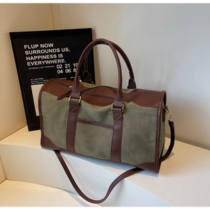 Detailed view of the olive green canvas tote bag with brown leather handles and strap