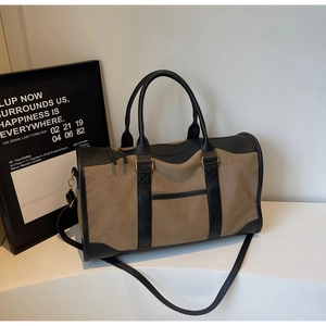 Close-up of large canvas tote bag with black leather handles and front pocket detail