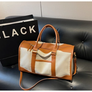 Detailed macro view of high-capacity canvas tote with dark brown leather trim and handles