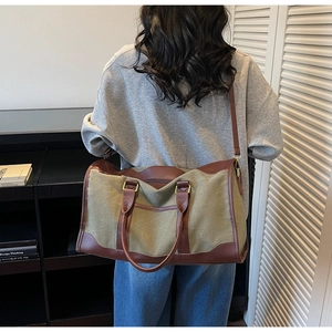 Olive canvas tote bag detail with brown leather trim and adjustable shoulder strap